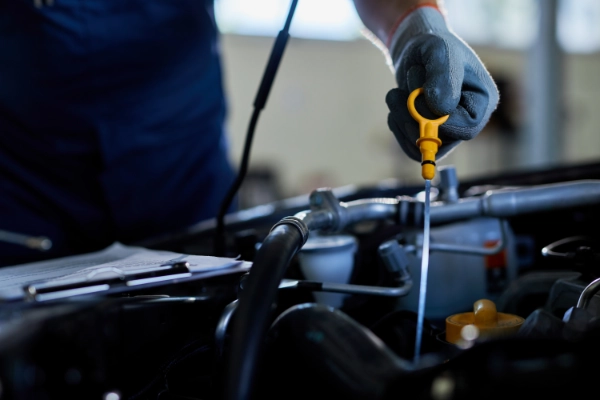 Mecânico inspecionando detalhadamente o nível de óleo do motor através da vareta de medição